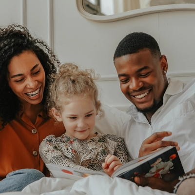Adoptive parents reading with their child.